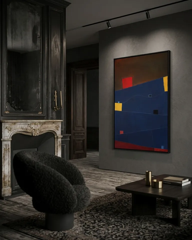 A vertical abstract painting hangs on a textured gray plaster wall under track lighting. The canvas displays a large central blue field with incised lines, a bright red block, and yellow side stripes. To the left of the artwork, a classical white marble fireplace and dark wood paneling are visible, with a black bouclé armchair in the foreground.