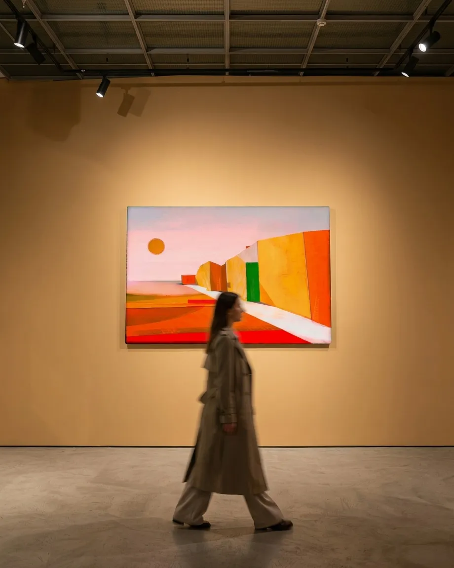 VIA SOLIS by Maurizio Valch, a horizontal painting in red, yellow, orange, and pale pink, displayed on a large gallery wall; a woman walks in front of the work.