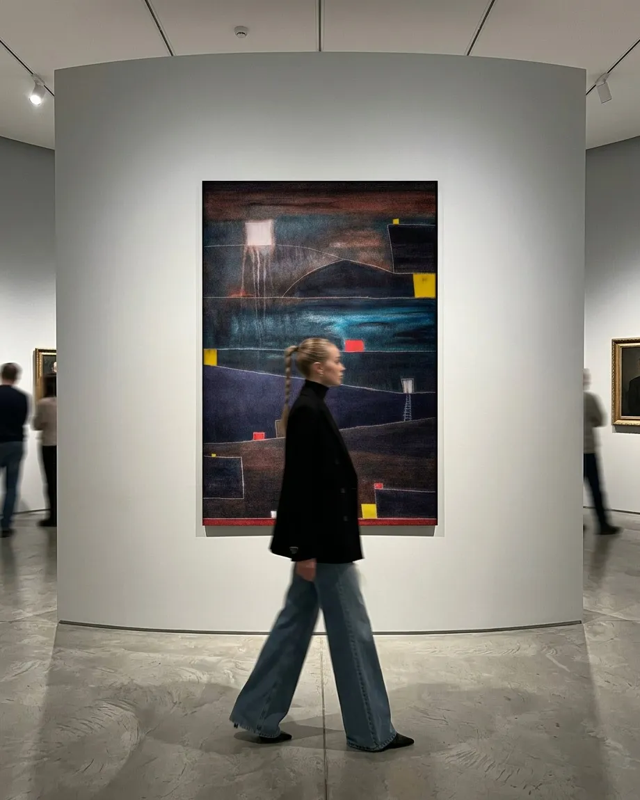 ADITUS by Maurizio Valch, an 80 by 120 cm vertical abstract painting installed on a curved gallery wall, with a visitor walking in front of it. The work combines dark bands, turquoise, and red and yellow accents.