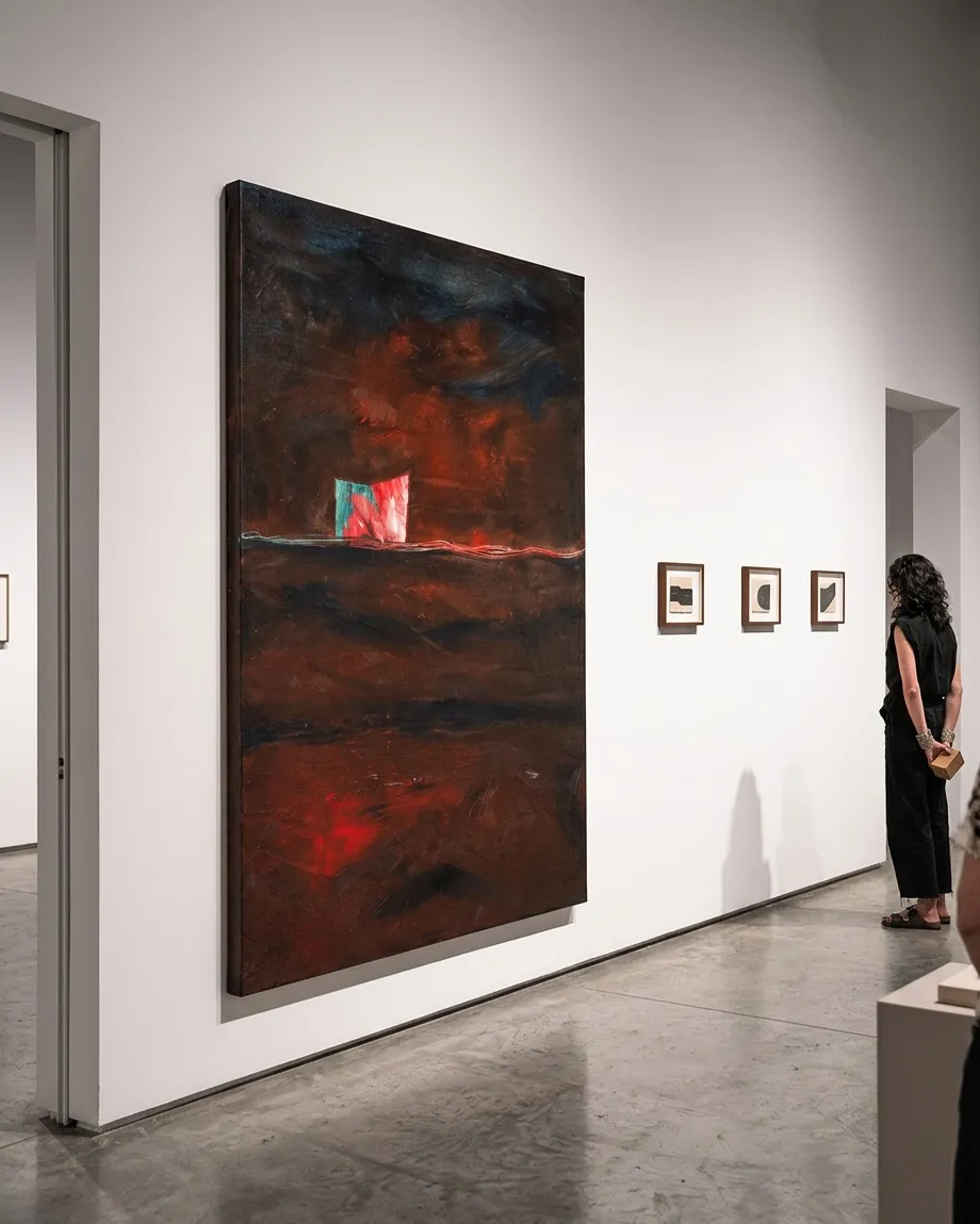 Large-format abstract oil painting exhibited in a white-walled room, next to a person observing it in profile.