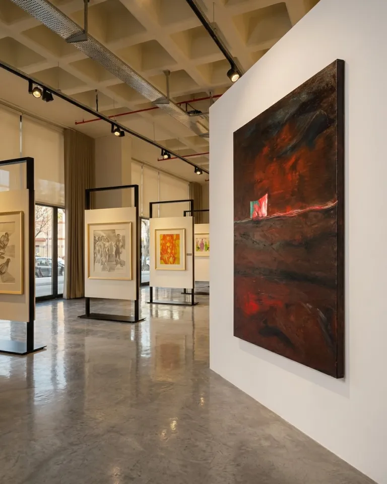 Maurizio Valch's painting hanging on a white partition wall inside an exhibition room with track lighting and polished concrete floors.