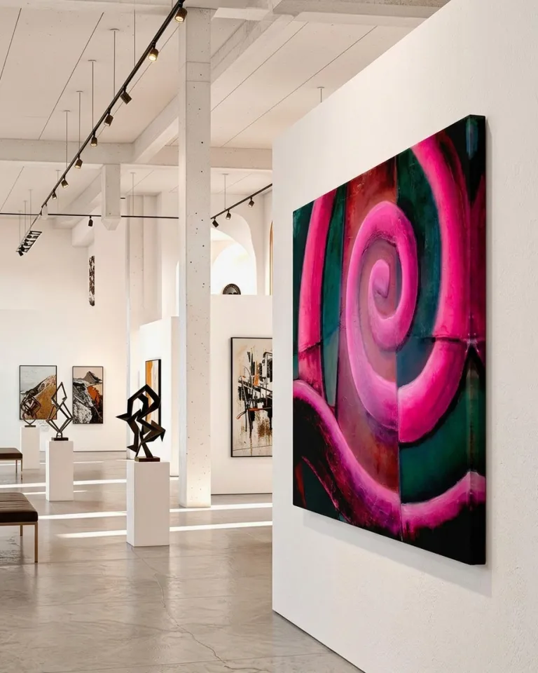 Vista angular de la pintura abstracta VORAGO de Maurizio Valch en una moderna galería de arte blanca rodeada de esculturas sobre pedestales.