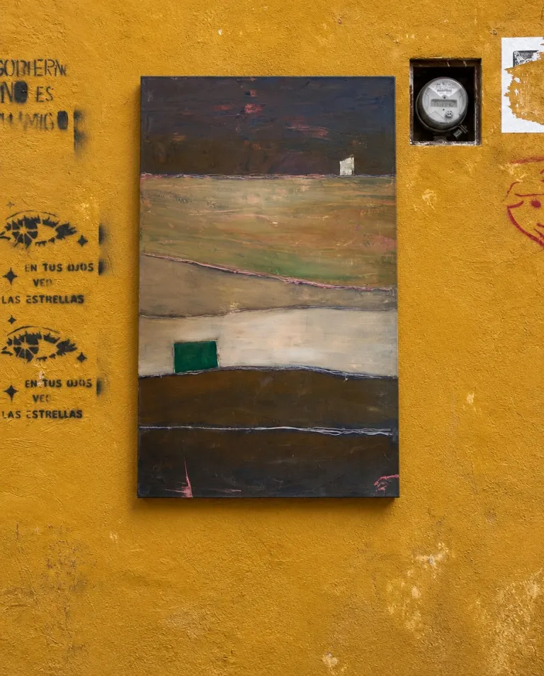 QUIES, a vertical abstract painting by Maurizio Valch, installed on an ochre exterior wall with graffiti, stencilled text and an electricity meter on the right.