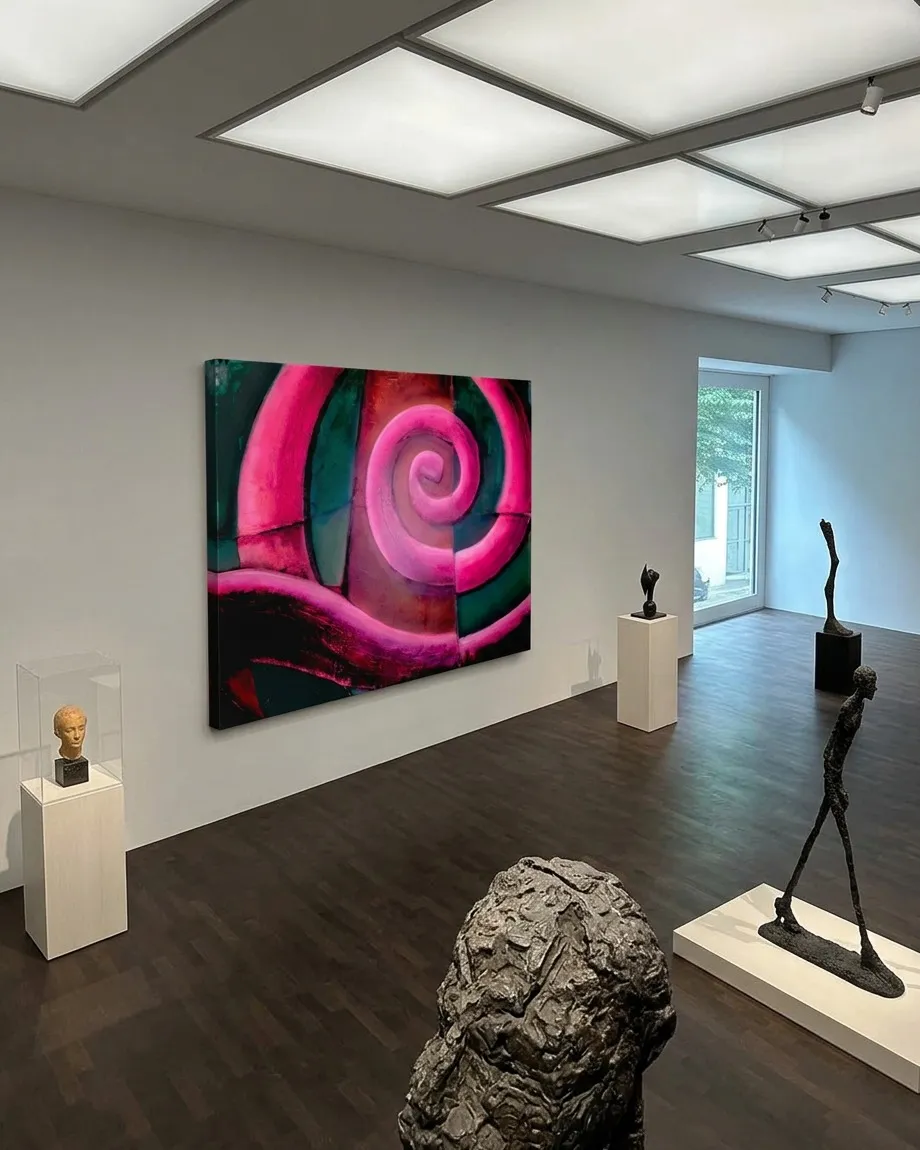Vista aérea de la pintura abstracta VORAGO colgada en una galería de arte minimalista con esculturas exentas sobre pedestales, iluminación de techo y suelos de madera oscura.