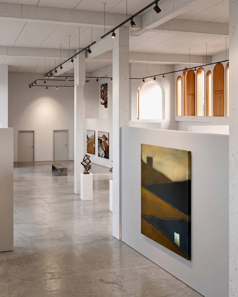 Pintura abstracta de Maurizio Valch titulada TENSUM colgada en la pared blanca de una luminosa galería de arte contemporáneo con columnas de hormigón.
