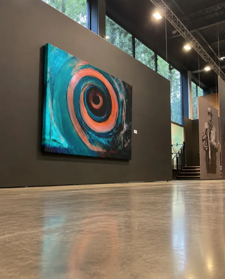 Gran cuadro abstracto HELIX de Maurizio Valch colgado en una sala de exposición de techos altos y suelo pulido, capturado desde un ángulo contrapicado.
