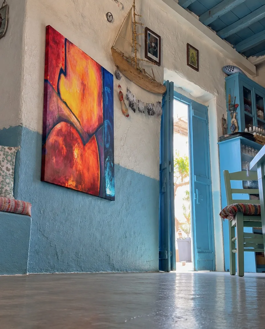 Pintura abstracta VERSUM de Maurizio Valch en la pared azul y blanca de una taberna rústica de estilo mediterráneo.