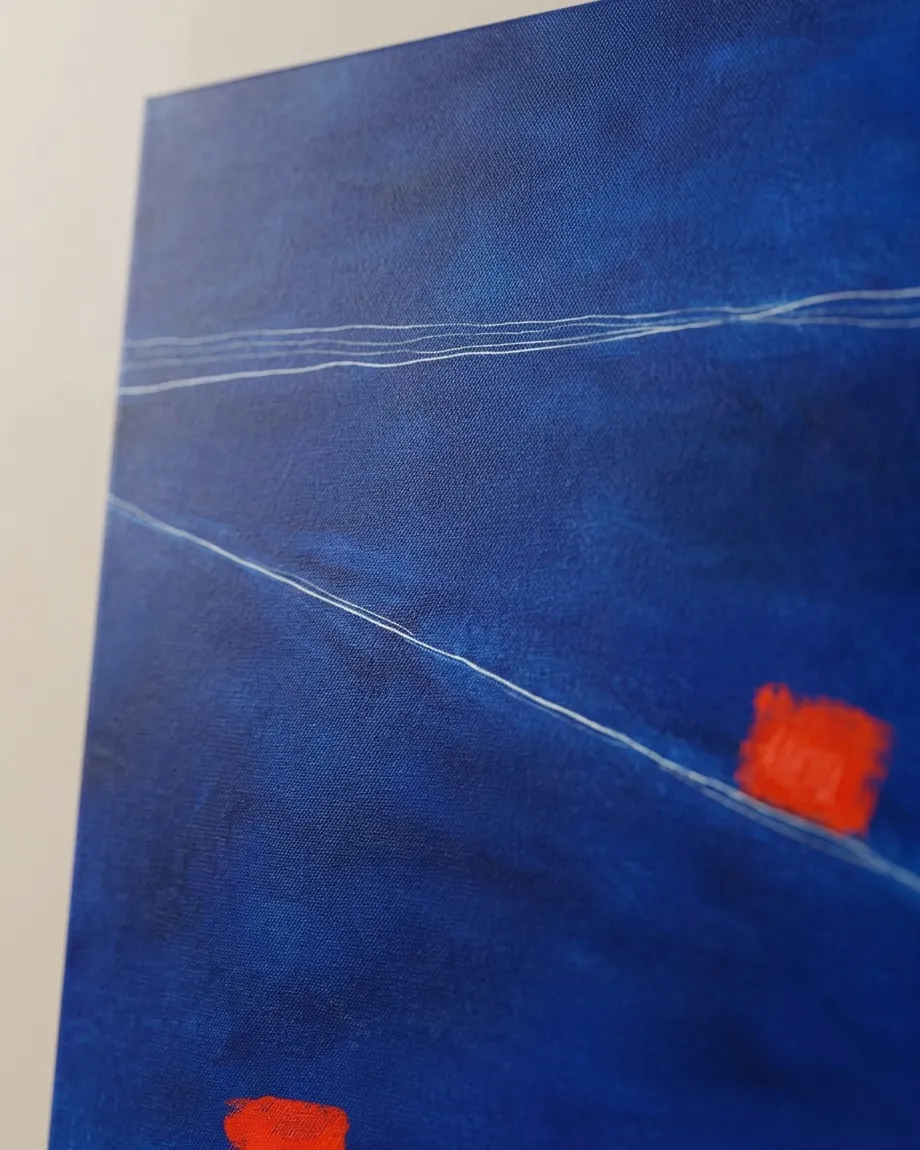 Detalle en primer plano de la obra abstracta SUBMERSA de Maurizio Valch, mostrando la textura del lienzo azul, lineas incisas blancas y una mancha roja intensa.