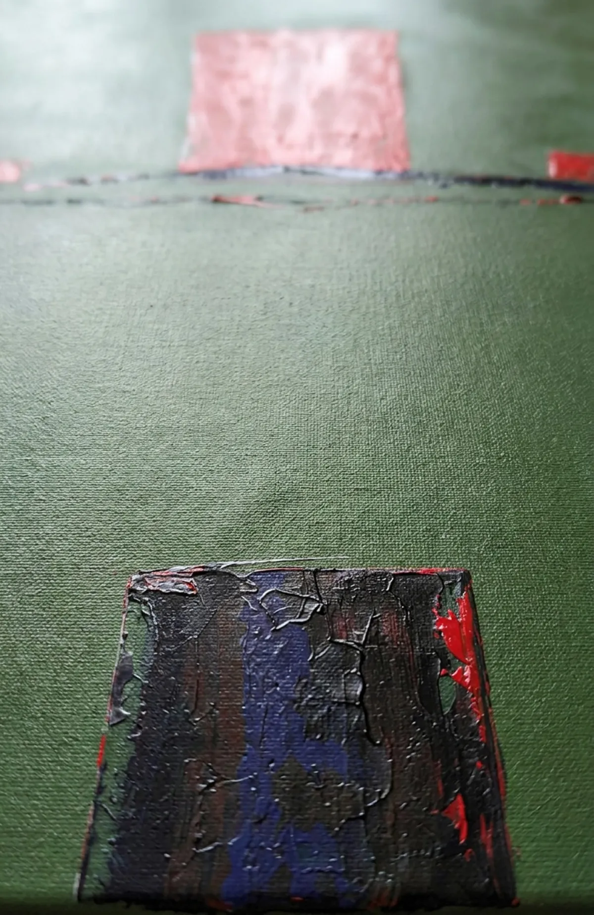 Primer plano extremo de la base de la pintura ASCENSUS, mostrando la textura rugosa del bloque oscuro inferior sobre el lienzo verde.